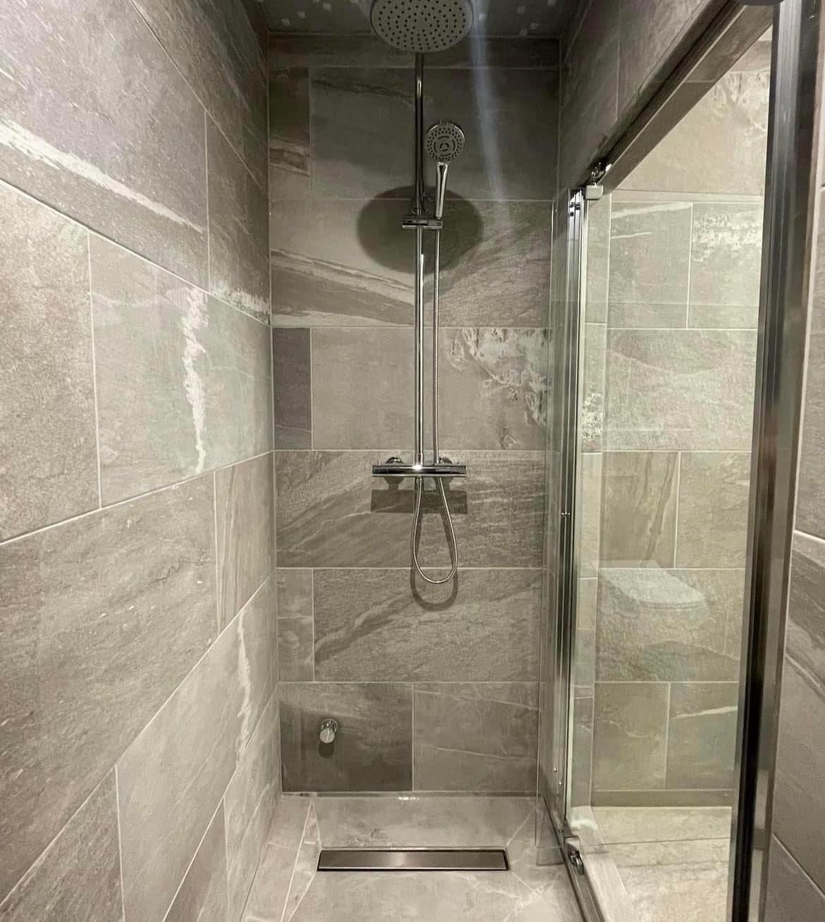 Walk-in shower in large grey tiles